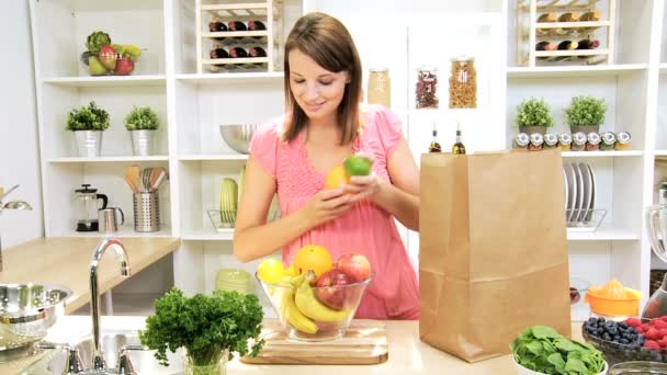 Kaukasisk kvinna uppackning shoppingväska frukt — Stockvideo