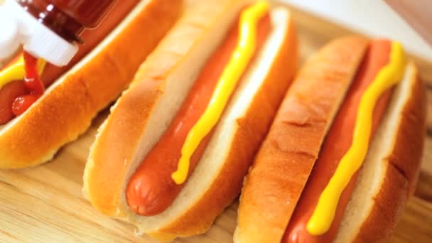 Hot Dog zum Mitnehmen garniert mit gelbem Senfketchup — Stockvideo