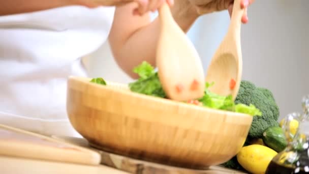 Gadis di meja dapur mencampur daun salad — Stok Video