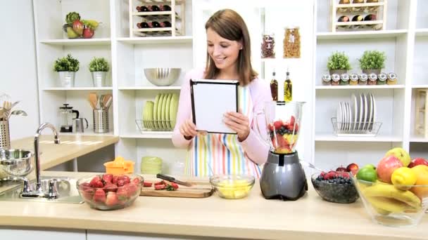 Jovem menina sem fio Tablet Receita Smoothie frutas frescas — Vídeo de Stock