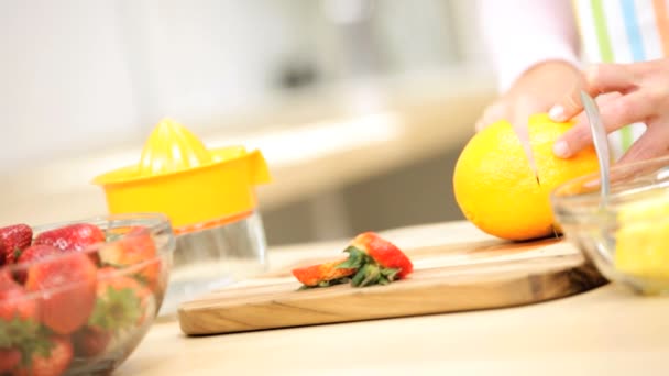 Chica en la cocina preparando jugo de naranja — Vídeos de Stock