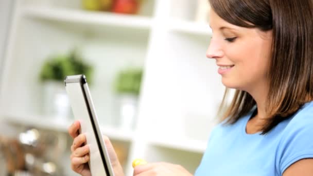Vrouw met behulp van draadloze tablet in kitchen — Stockvideo