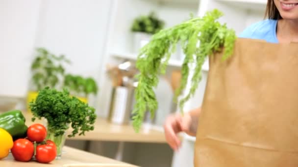 Vrouw in keuken uitpakken papieren zak — Stockvideo