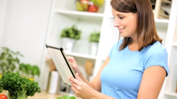 Жінка використовує бездротовий планшет на кухні — стокове відео