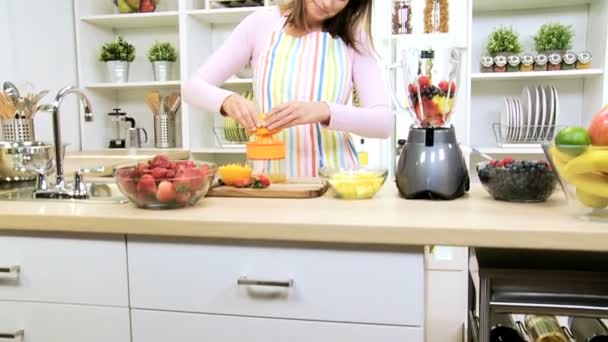 Kaukasiska tjej att göra färskpressad apelsinjuice — Stockvideo
