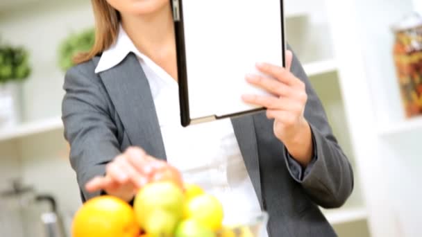 Businesswoman en la cocina usando la tableta inalámbrica — Vídeo de stock