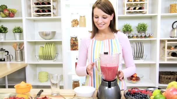 Menina morena usando o suco de frutas frescas liquidificador — Vídeo de Stock