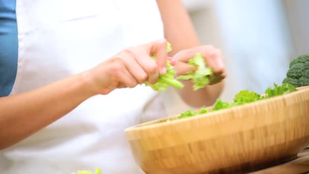 Chica en el mostrador de cocina preparando hojas de ensalada — Vídeo de stock