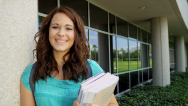 Estudante feminina carregando livros de biblioteca — Vídeo de Stock