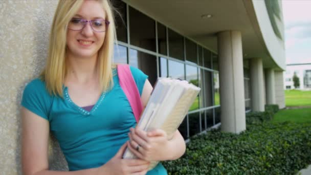 Estudante feminina carregando livros de biblioteca — Vídeo de Stock