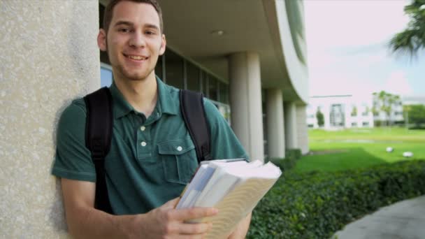 Estudante masculino segurando livros de biblioteca — Vídeo de Stock