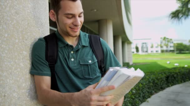 Manlig student håller bibliotekets böcker — Stockvideo