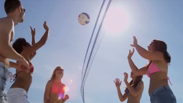 Amigos universitarios jugando voleibol en la playa — Vídeo de stock