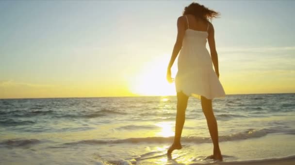 Lächelnde junge Frau genießt Sonnenaufgang am Strand — Stockvideo