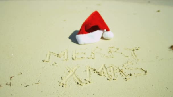 Santa hatt ligger på sandstranden — Stockvideo