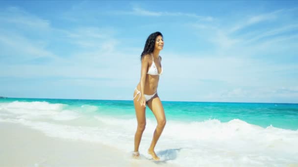 Girl wearing bikini splashing in ocean — Stock Video