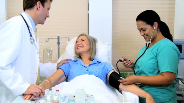 Enfermera comprobando la presión arterial del paciente femenino — Vídeos de Stock