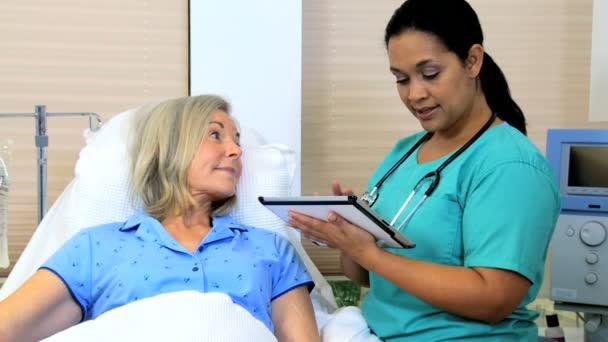 Медсестра записывает план ухода за пациентом на планшет — стоковое видео