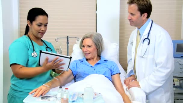 Медсестра записує історію хвороби пацієнта на планшеті — стокове відео