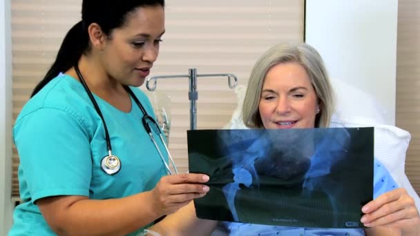 Female patient looking x-ray images with radiologist staff — Stock Video