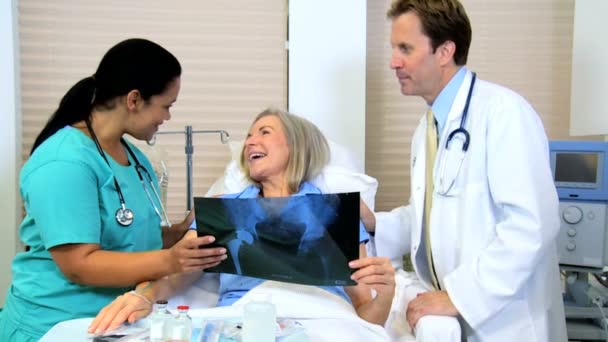 Female patient looking x-ray images with radiologist staff — Stock Video