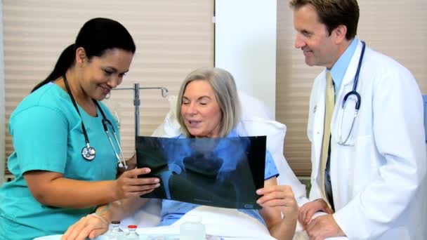 Vrouwelijke patiënt op zoek x-ray beelden met radioloog personeel — Stockvideo