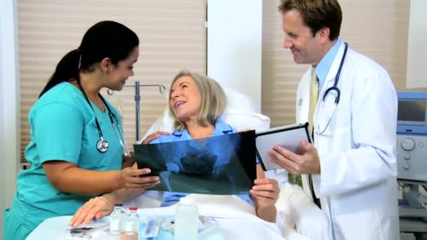 Personal del hospital discutiendo resultados de rayos X con el paciente — Vídeo de stock