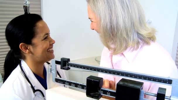 Nurse carrying out weight check of patient — Stock Video