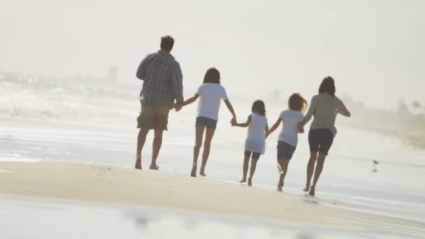 Familia caminando descalza a lo largo de la playa — Vídeo de stock