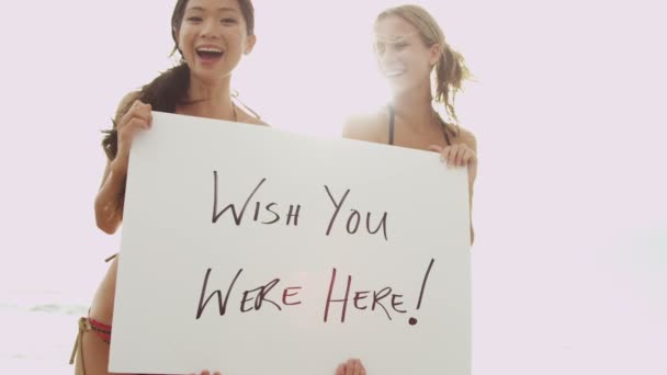 Meninas na praia com placa de mensagem — Vídeo de Stock
