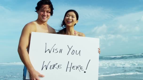 Couple on beach with white board — Stock Video