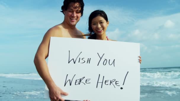 Pár na pláži s bílou tabuli — Stock video