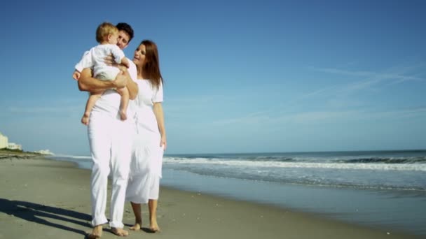 Parents avec bébé marchant sur la plage — Video