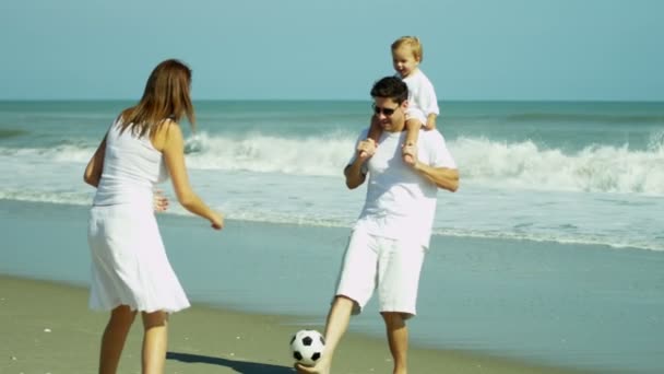 Ouders met baby voetballen op strand — Stockvideo