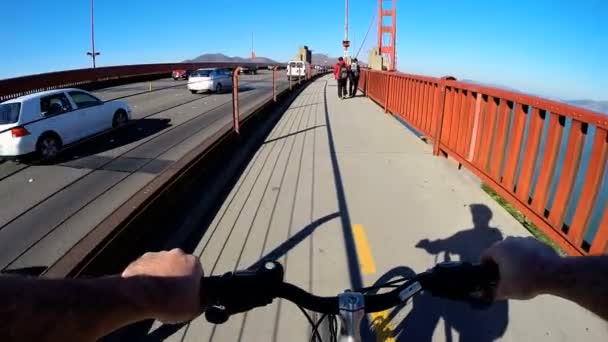 Radfahrer auf goldener Torbrücke — Stockvideo