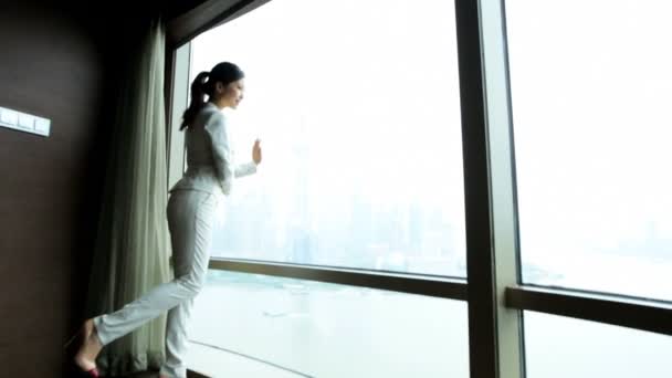 Businesswoman in hotel viewing cityscape — Stock Video