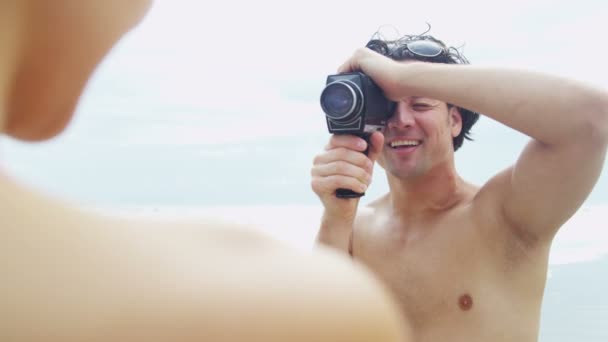 Pareja en la playa con cámara de vídeo — Vídeo de stock