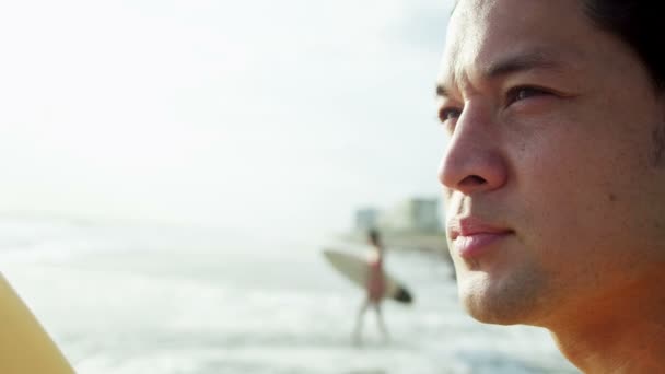 Homme tenant une planche de surf sur la plage — Video