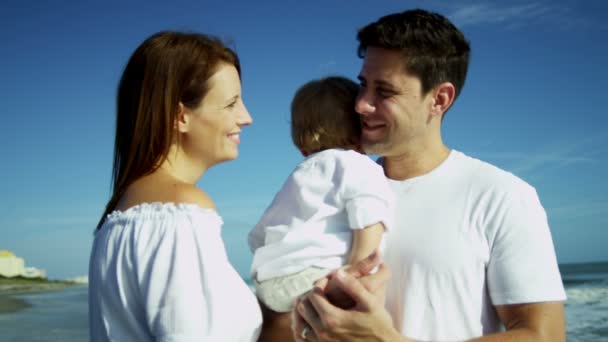 Parents holding son on sandy beach — Stock Video