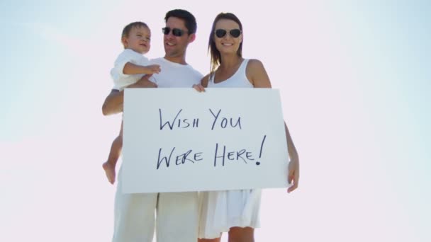 Familia en la playa sosteniendo tablero de mensajes — Vídeo de stock