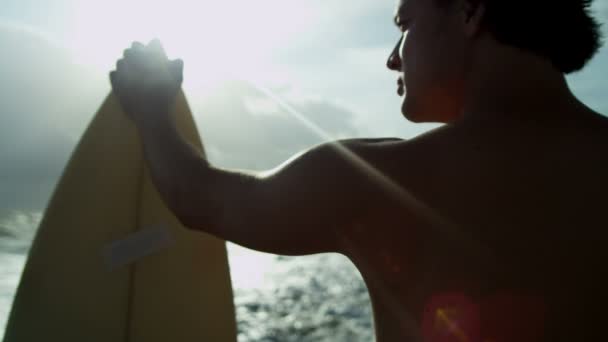 Homem segurando prancha na praia — Vídeo de Stock