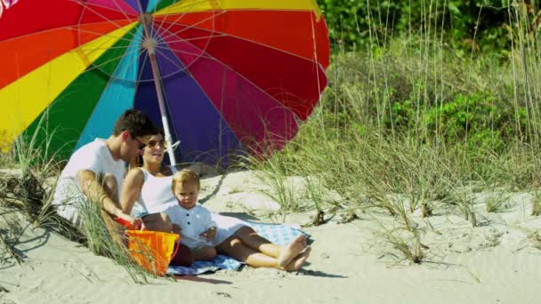 Eltern mit Baby spielen im Sand — Stockvideo