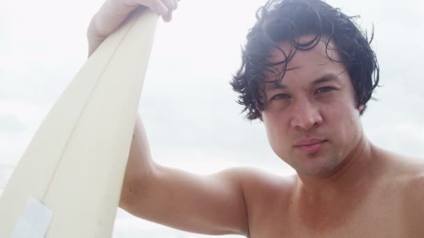 Человек на пляже с доской для серфинга — стоковое видео