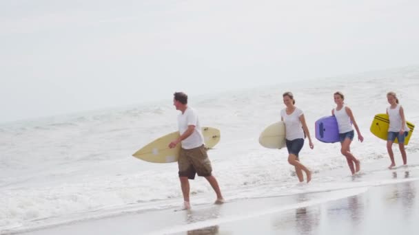 Family walking across sandy beach — Stock Video