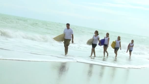 Família caminhando com bodyboards na praia — Vídeo de Stock