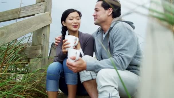 Pareja en la playa bebiendo café — Vídeos de Stock