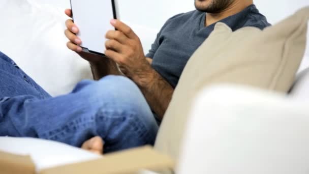 Homem no sofá usando tablet — Vídeo de Stock