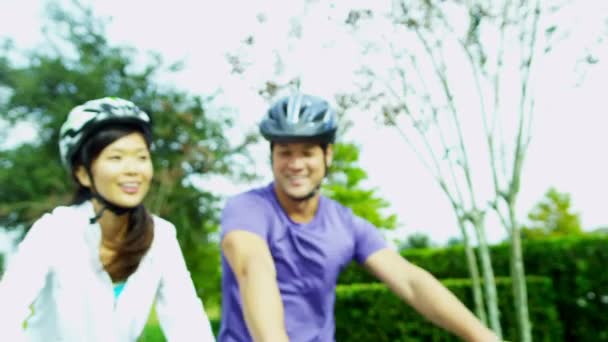 Ευτυχισμένο εθνοτικές ζευγάρι ποδηλασία μαζί σε εξωτερικούς χώρους — Αρχείο Βίντεο