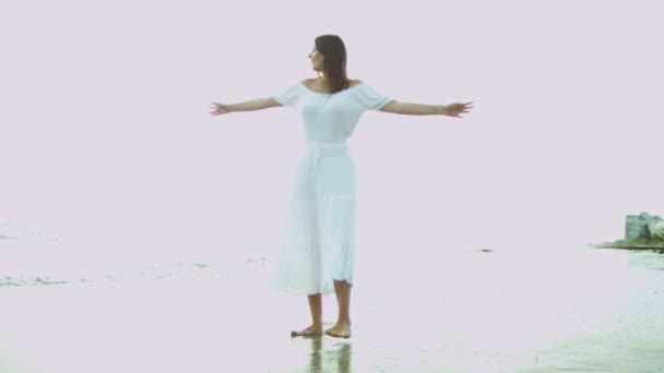 Женщина в белом платье рядом с океаном — стоковое видео