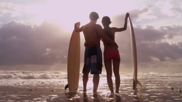 Surfeurs au coucher du soleil regardant les vagues — Video